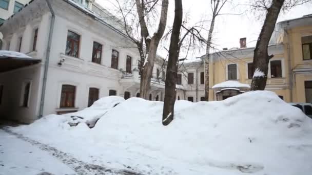 Panorama van kleine binnenplaats met sneeuw banken en geparkeerde auto's. — Stockvideo