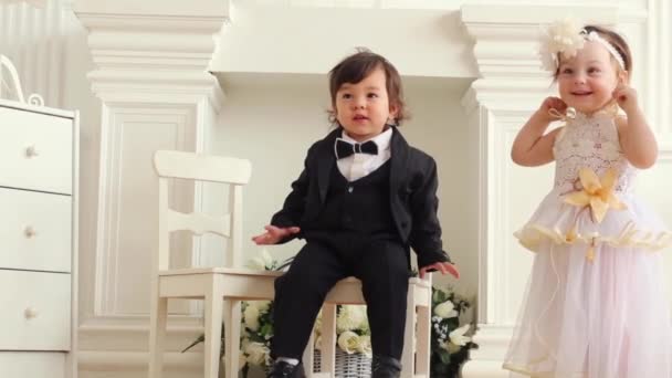Μωρό αγόρι με τη στολή του γαμπρού και μωρό κορίτσι με το κοστούμι της νύφης — Αρχείο Βίντεο