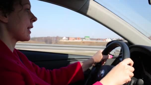 Mooie sprekende vrouw in rode jas stations auto op zomerdag — Stockvideo