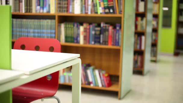 Hoek van de tafel tegen een onscherpe achtergrond van boekenkasten — Stockvideo