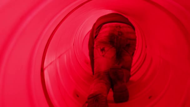 Back of boy creeping in red pipe on children playground — Stock Video