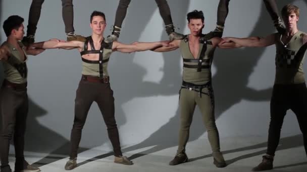 Seven young men in medieval costumes do acrobatic pyramid — Stock Video