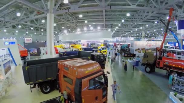 Les visiteurs marchent par pavillon avec des machines de construction — Video