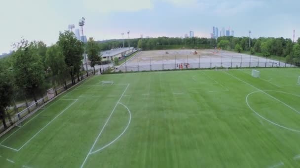 Yaz bulutlu bir günde inşaat alanı yakınında Futbol sahası — Stok video