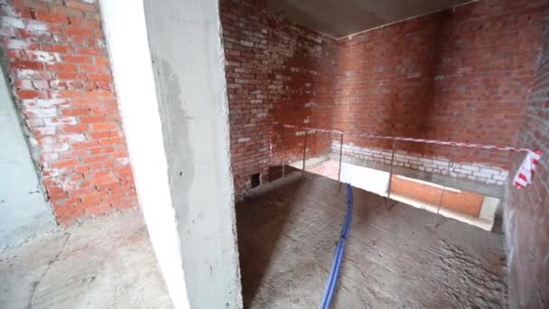 Rum med tegelväggar och balkong i byggnad under uppbyggnad — Stockvideo