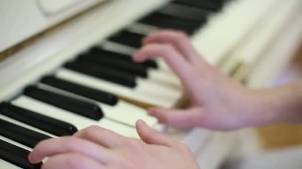 Beautiful long-fingered hands of girl playing white piano — Stock Video