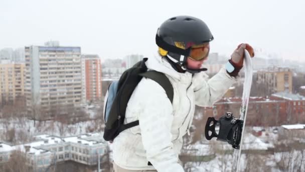 Snowboardzista dziewczyna w kask i okulary stojące na wzgórzu — Wideo stockowe