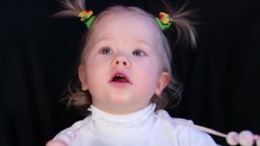 Tatlı küçük kız beyaz kazaklı pigtails başında ile.