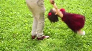 Baba kızının ellerini tutarak ve onu etrafında dönen