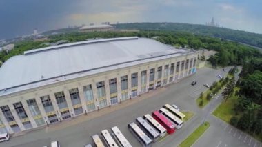Yaz bulutlu bir günde büyük spor salonuyakınında park etmiş birkaç otobüs