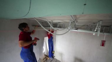 Bina seviyesi ölçüsü tavan profili ayarlı iki işçi