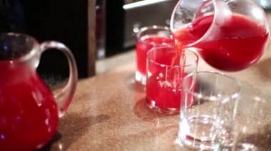 Barmen sürahi bardaklarda gelen kırmızı içecek tezgahın üzerine dökülen..