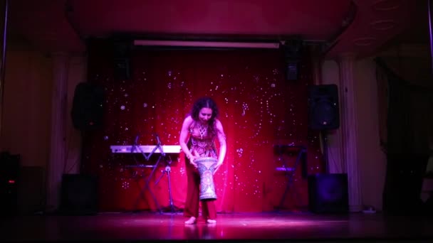 Mladá žena v červené kostým tance břišní tanec na jevišti — Stock video