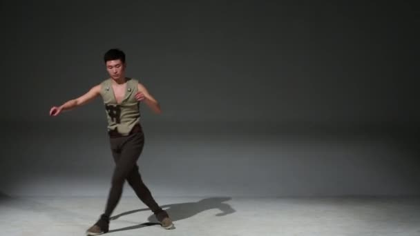 Asian acrobat man in medieval hunting costume jumps in studio — Stock Video