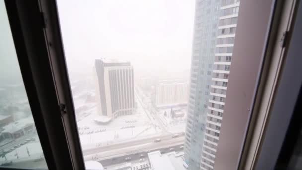 Bovenaanzicht van ramen naar hoog gebouw tijdens sneeuwval — Stockvideo