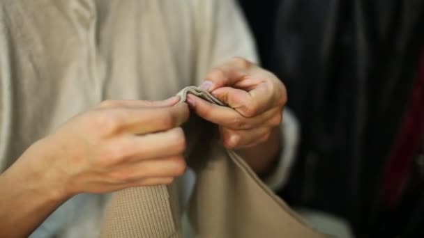 Mannelijke handen naai handmatig trui beige kleren voor prestaties — Stockvideo