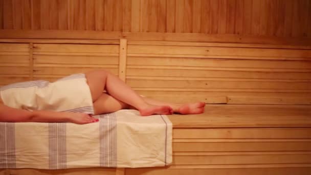 Bella donna rilassante sullo scaffale nella spaziosa sauna — Video Stock