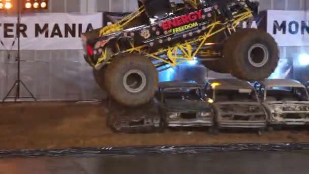 巨大なオフロードは、スポーツエンターテイメントショーで古い車を粉砕 — ストック動画