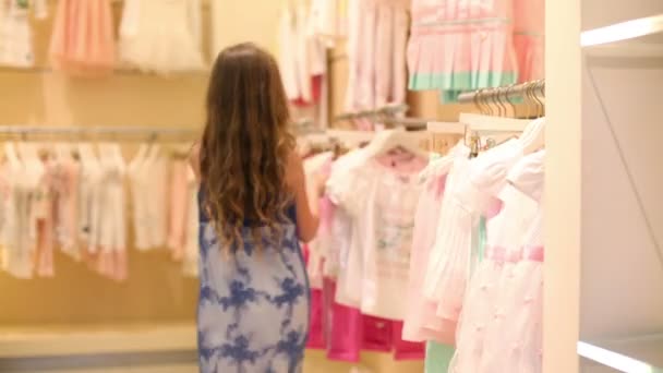 Κορίτσι επιλέγει τα ρούχα στη συλλογή παιδιών Jakimanka — Αρχείο Βίντεο