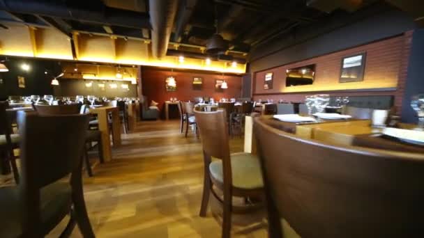 Vandring längs rymlig restaurang hall mellan rader av bord. — Stockvideo