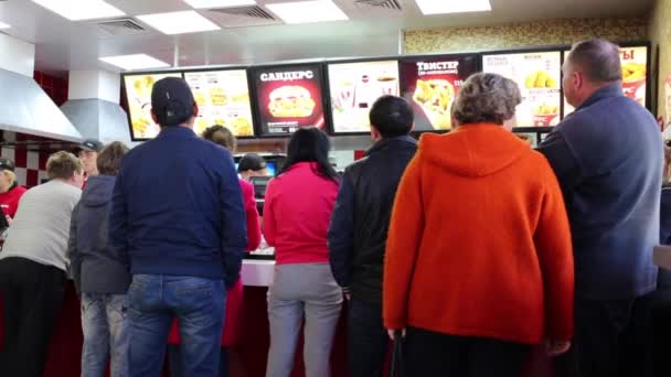 Люди очікують їжі в ресторані KFC в Москві. — стокове відео