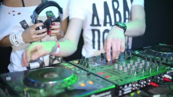 Mãos de DJ cara e menina de pé atrás da máquina no clube noturno — Vídeo de Stock