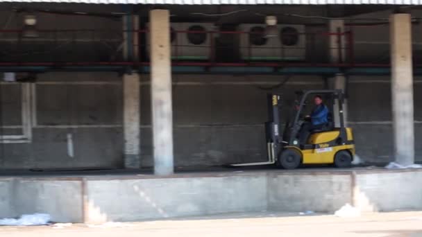 Uomo su un camion forcella cavalca da rampa a autotruck con merci . — Video Stock