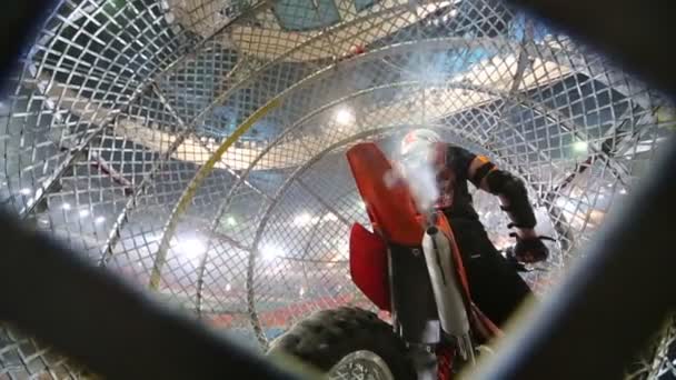 Motociclista desligar o motor da motocicleta dentro de uma bola de malha de metal — Vídeo de Stock
