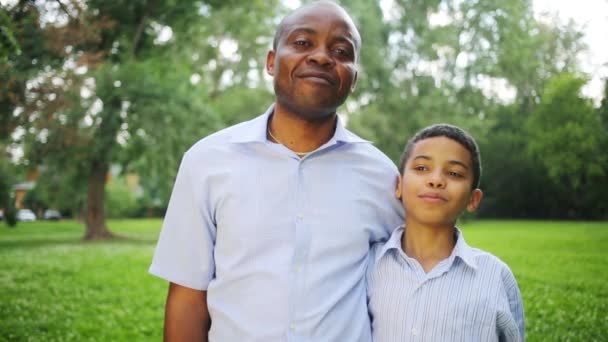 Feliz padre e hijo de pie abrazándose en el parque de verano — Vídeos de Stock