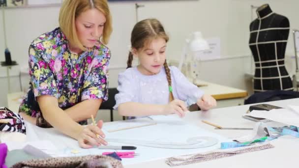 Alfaiate feminino olha como estudante menina desenha padrões para roupas — Vídeo de Stock