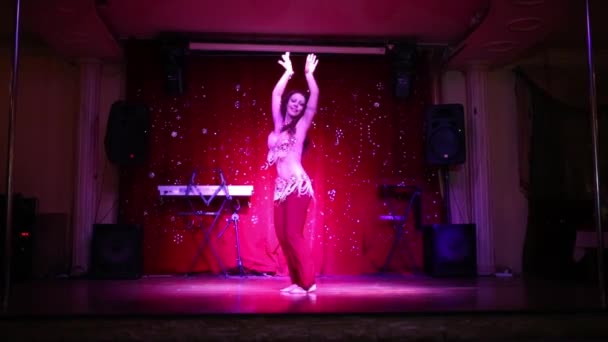 Hezká mladá žena v červené kostým tance břišní tanec na jevišti — Stock video