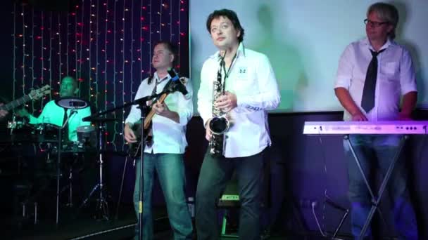 Grupo musical de cinco homens com saxofone se apresentam no show — Vídeo de Stock