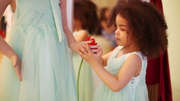 Lille pige sætter blomst til hånd mannequin i galleriet – Stock-video