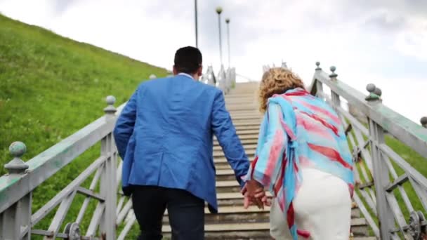 Dos de la femme enceinte en blanc et élégant homme montant les escaliers — Video