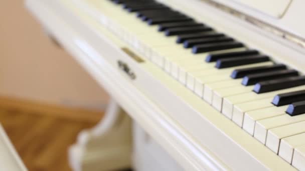 Toetsenbord van witte oude mooie piano in lege lichte ruimte — Stockvideo