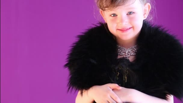 Little girl with fur cape on her shoulders poses to camera. — Stock Video