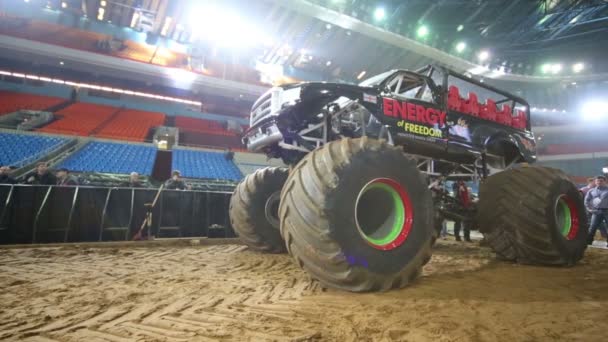 The giant offroader with huge wheels rides on the sandy arena — Stock Video