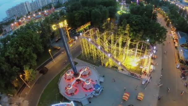 Amusements in park of VVC against cityscape at spring evening. — Stock Video
