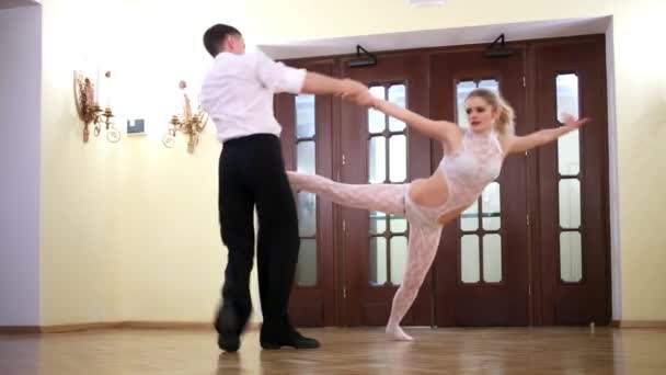 Dancer takes his partner by hand and leg, rotates her and puts — Stock Video