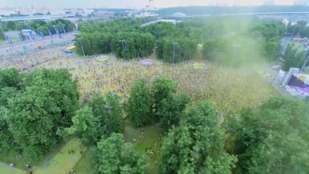 多くの人々は、インドの塗料の祭りの間に公園広場を歩きます — ストック動画