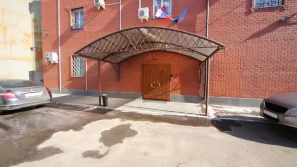 Puerta de entrada a un moderno edificio de ladrillo rojo de dos plantas — Vídeo de stock