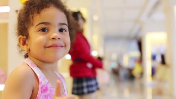 Petite fille pouces levés et sourires dans le magasin des enfants — Video