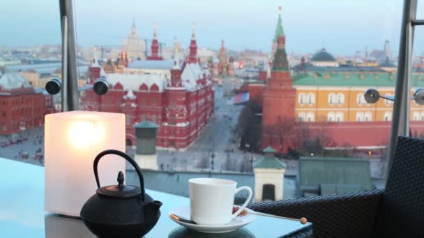 Théière avec tasse sur la table dans un café confortable avec vue sur la Place Rouge — Video