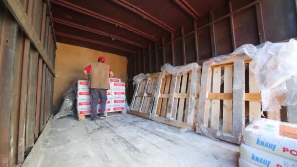 Homme décharger camion avec des sacs de mortier sec Knauf . — Video