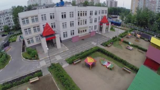 Детский сад с детскими площадками рядом с жилыми домами — стоковое видео