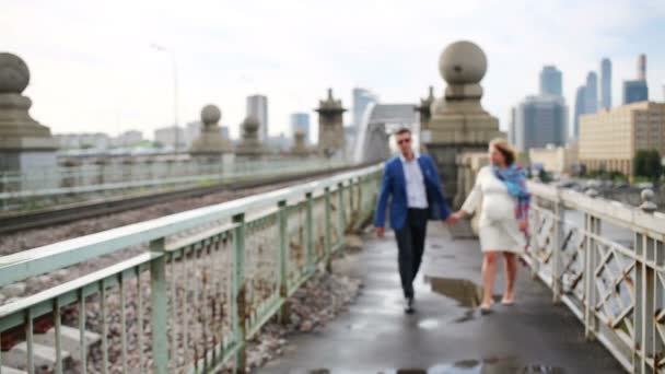 Pregnant woman and stylish man walk together near railway — Stock Video