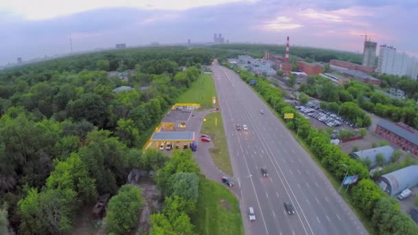 Поездка на автомобилях по автостраде возле автозаправочной станции и промышленной зоны — стоковое видео