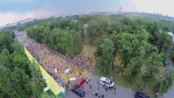 Muitas pessoas caminham pelo parque durante o festival de tintas indianas — Vídeo de Stock