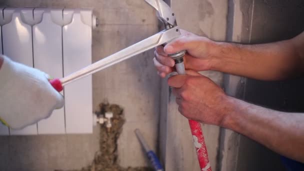 Workers prepare pipes for heating system crimping. — Stock Video