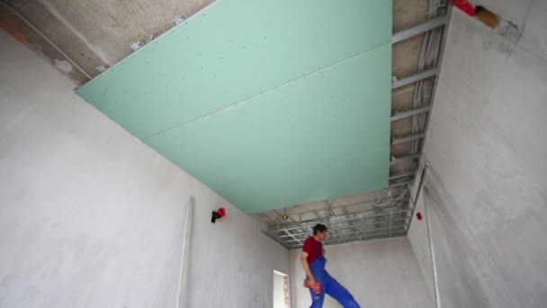 Homens verificar a precisão do quadro de instalação para o teto pendurado — Vídeo de Stock